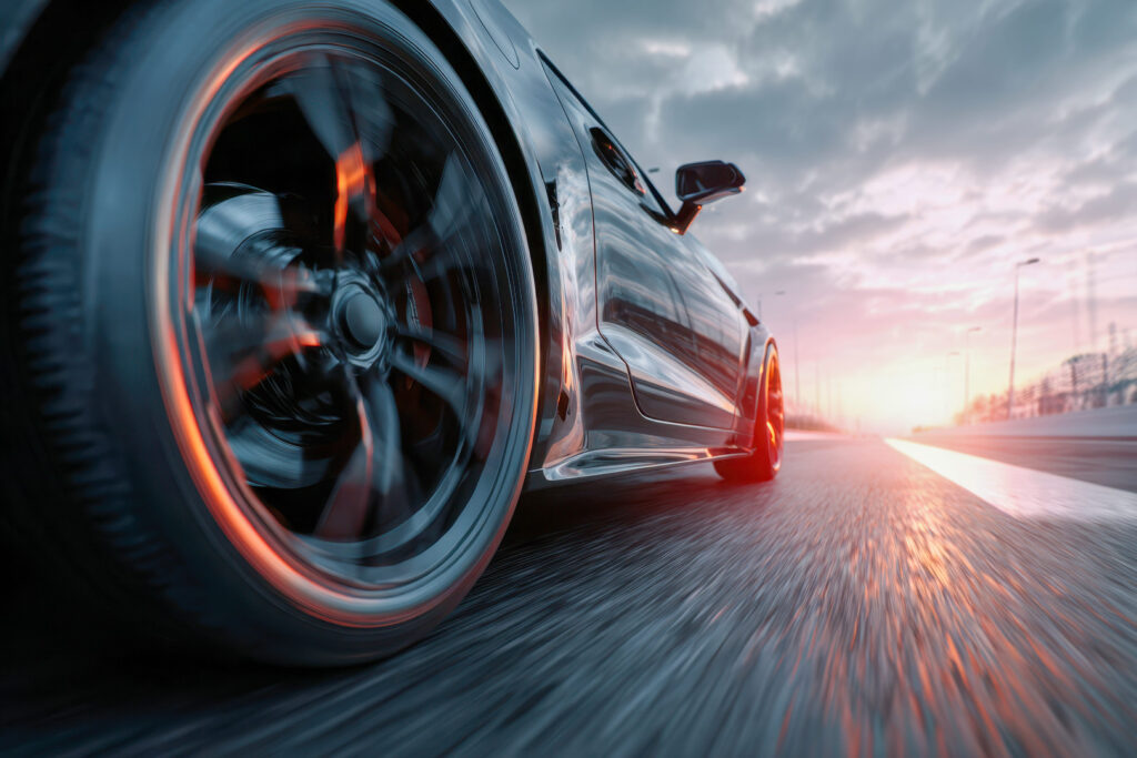 Auto jazdiace po diaľnici s pneumatikami s nízkym valivým odporom symbolizujúce nižšiu spotrebu paliva pneumatík